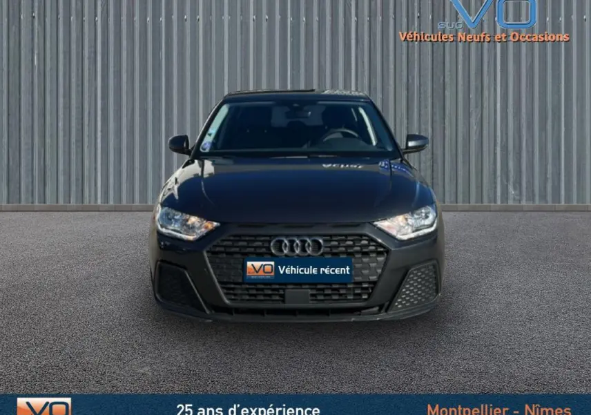 Vue frontale d'une Audi A1 Sportback gris foncé 2020 avec calandre noire et phares allumés.