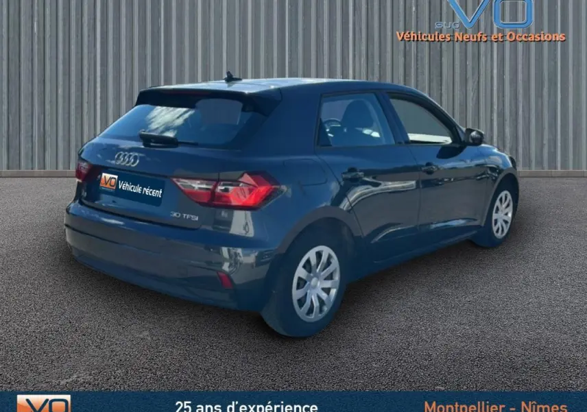Audi A1 Sportback gris foncé vue 3/4 arrière droit, avec feux arrière et jantes visibles sur fond neutre.