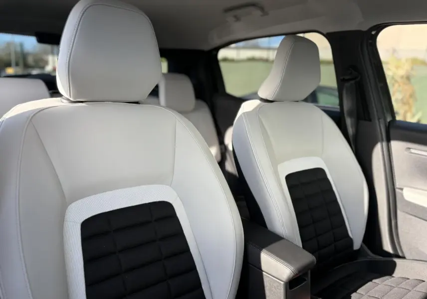 Vue intérieure rapprochée des sièges avant en cuir blanc et tissu noir du Citroën C3 Aircross 2025.