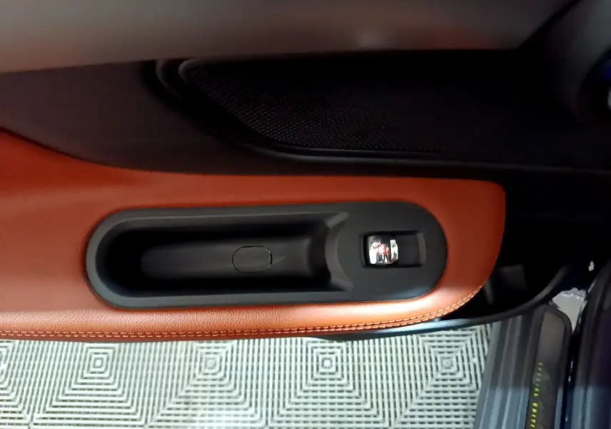 Poignée intérieure côté droit en cuir marron du MINI COUNTRYMAN Cooper SE 2021 avec bouton de verrouillage noir.