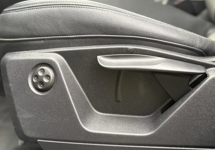 Détail du réglage manuel du siège avant en cuir noir de l'Audi Q2 35 TDI S-Line, côté gauche.