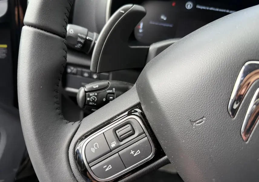 Vue rapprochée du volant noir du Citroën C5 Aircross 1.5 HDi 130, avec commandes intégrées et tableau de bord numérique.