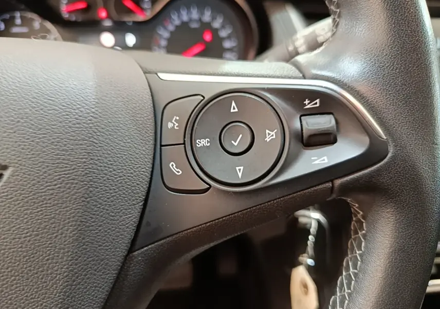 Gros plan sur le volant multifonctions en cuir de l'Opel Grandland X 1.5 Diesel 130 GS Line 2021, boutons de commande visibles.
