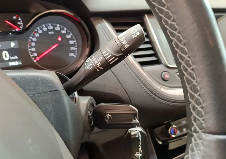 Vue rapprochée du tableau de bord et du volant cuir d’un Opel Grandland X gris foncé avec clé insérée.