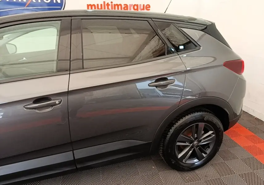 Vue latérale côté droit de l’Opel Grandland X gris foncé, mettant en valeur les jantes alliage et les poignées de porte.