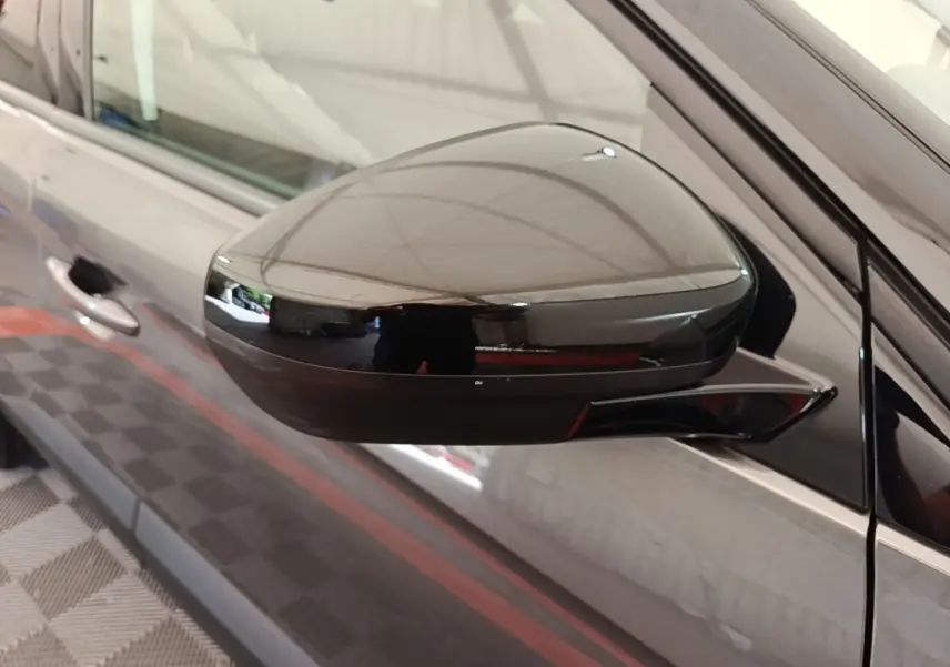 Rétroviseur côté gauche noir brillant d’un Opel Grandland X gris foncé, vue rapprochée sur la portière avant.