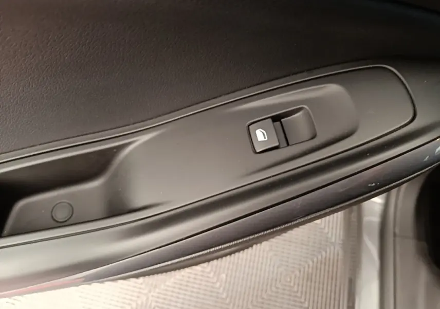 Gros plan sur la commande de verrouillage des portes côté conducteur de l'Opel Grandland X gris foncé.