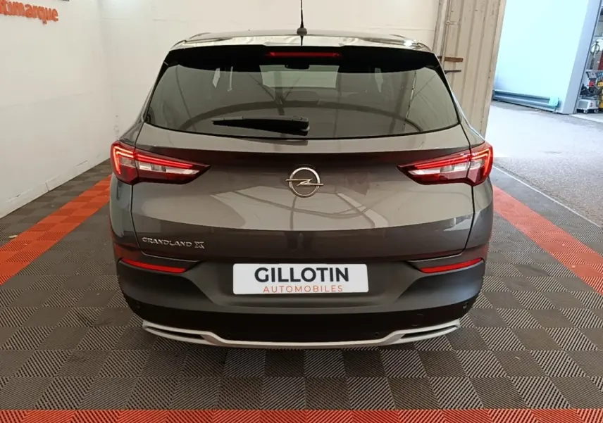 Vue arrière d'un Opel Grandland X gris foncé 2021 avec feux LED et logo central sur hayon.
