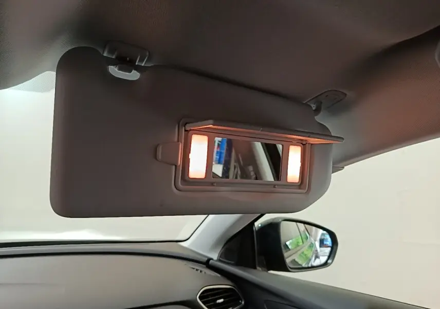Détail intérieur du pare-soleil côté conducteur avec miroir éclairé dans un Opel Grandland X gris foncé.