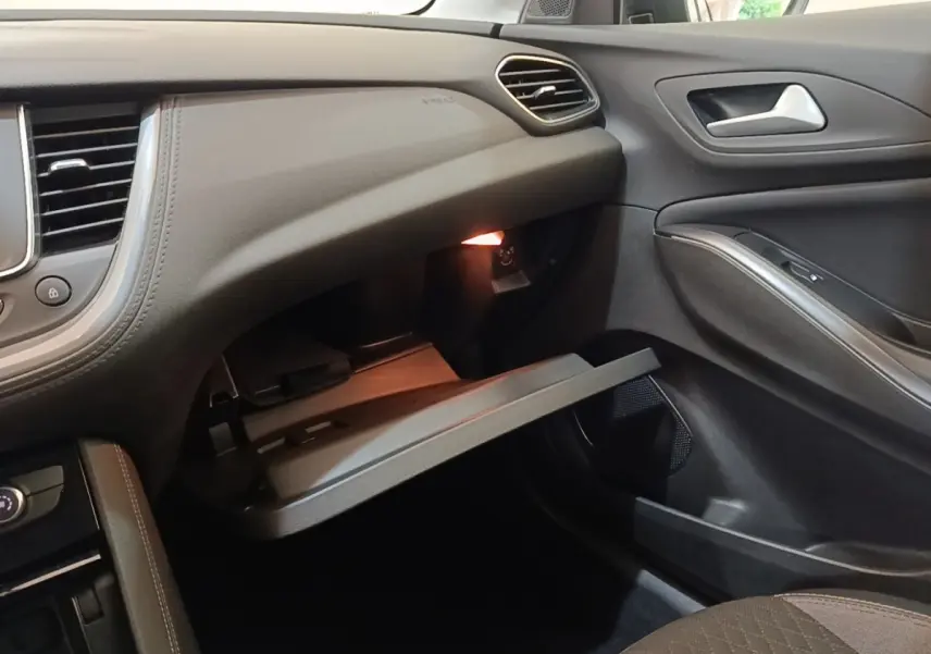 Intérieur côté passager de l’Opel Grandland X 2021, boîte à gants ouverte, garnitures noires et grises.