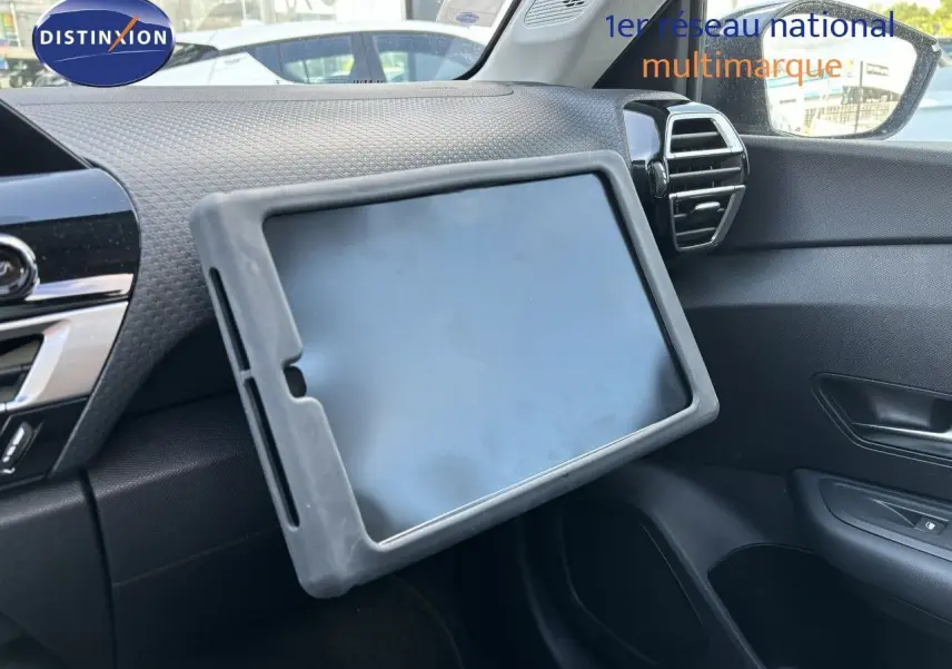 Tablette posée sur la planche de bord côté passager d'une Citroën C4 Gris Artense 2022, intérieur noir.