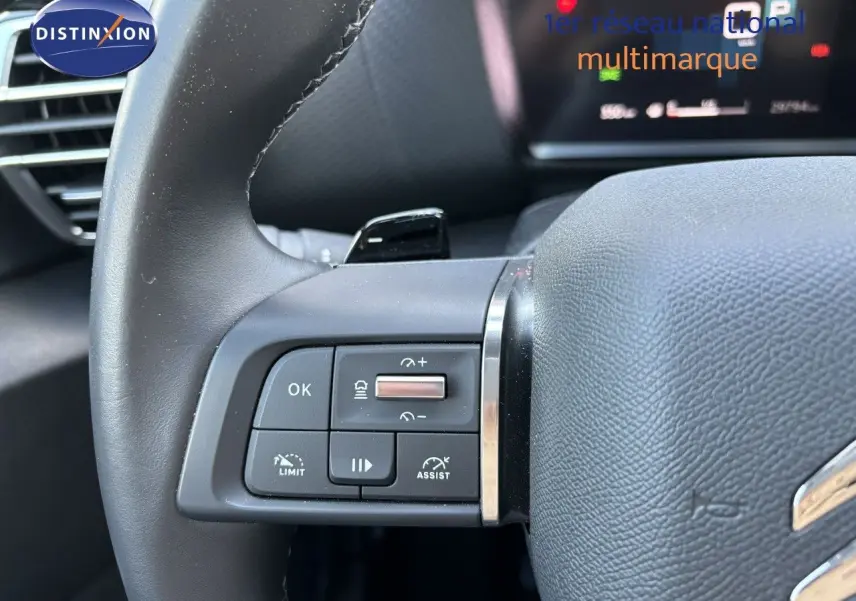 Gros plan sur les commandes au volant à gauche d'une Citroën C4 gris Artense 2022 avec régulateur et assistant de conduite.