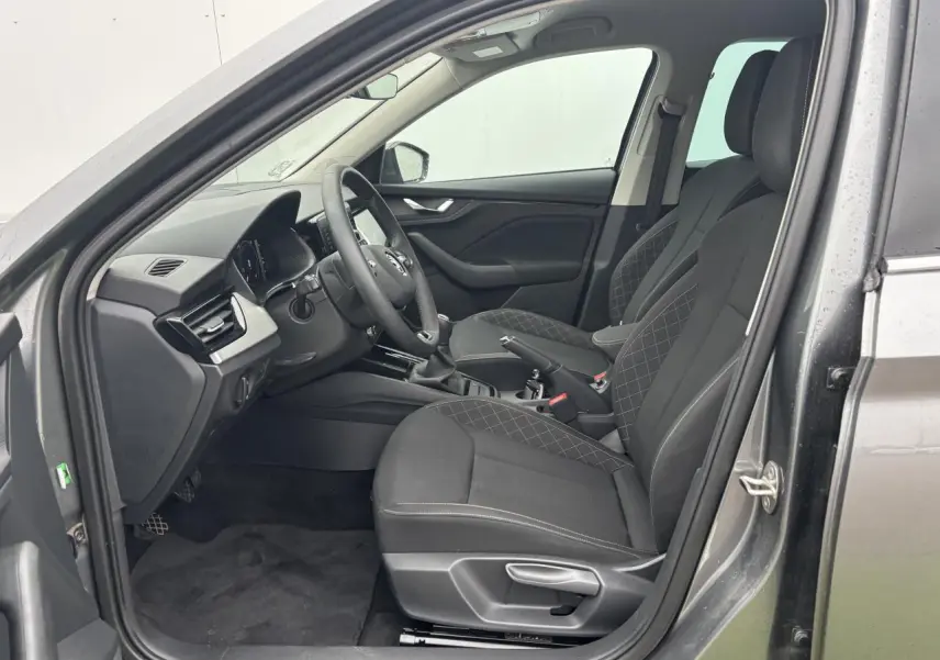 Intérieur côté conducteur du Skoda Kamiq gris graphite, sièges tissu Ambition noirs avec surpiqûres et volant cuir multifonctions.
