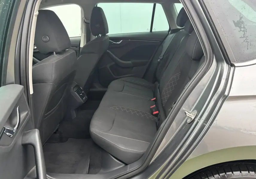 Vue côté gauche arrière du Skoda Kamiq gris graphite métal, montrant les sièges arrière en tissu avec surpiqûres croisées.