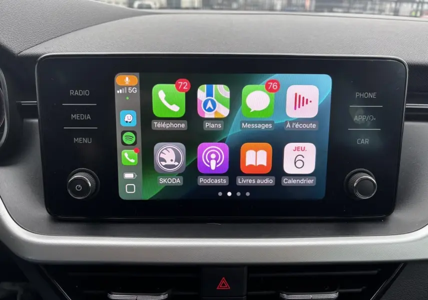 Écran tactile central du Skoda Kamiq 2024 affichant Apple CarPlay avec applications et commandes autour.
