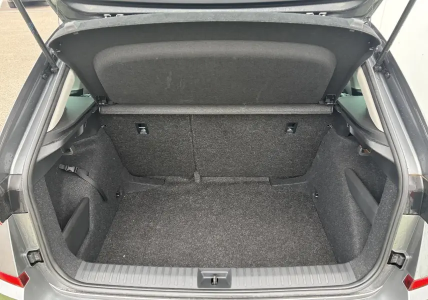 Coffre ouvert vu de l'arrière d'un Skoda Kamiq gris graphite métallisé, intérieur en tissu noir.