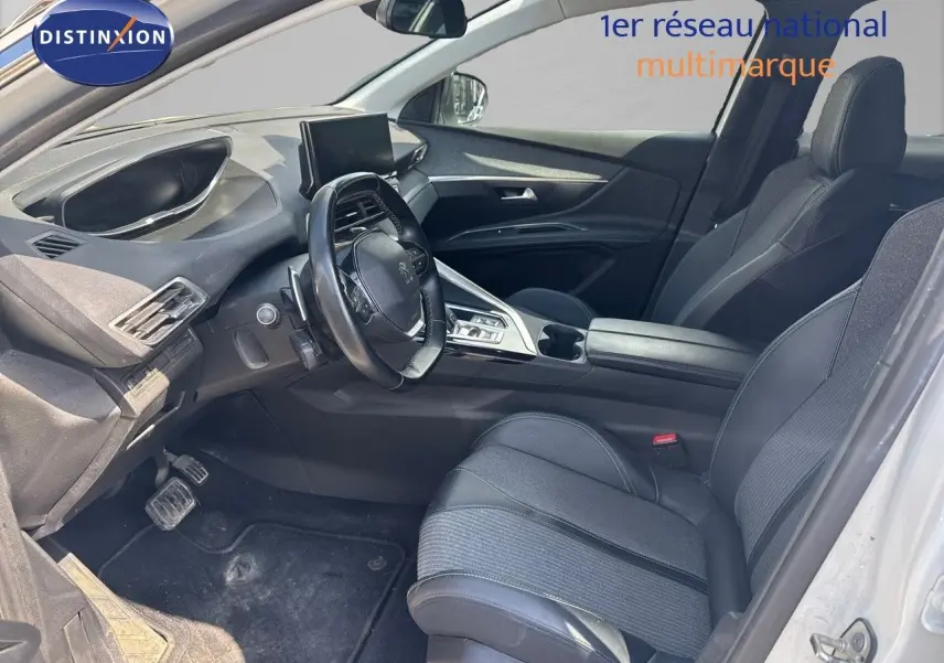 Intérieur noir du Peugeot 3008 blanc nacré 2022, vue côté conducteur avec tableau de bord et console centrale visibles.