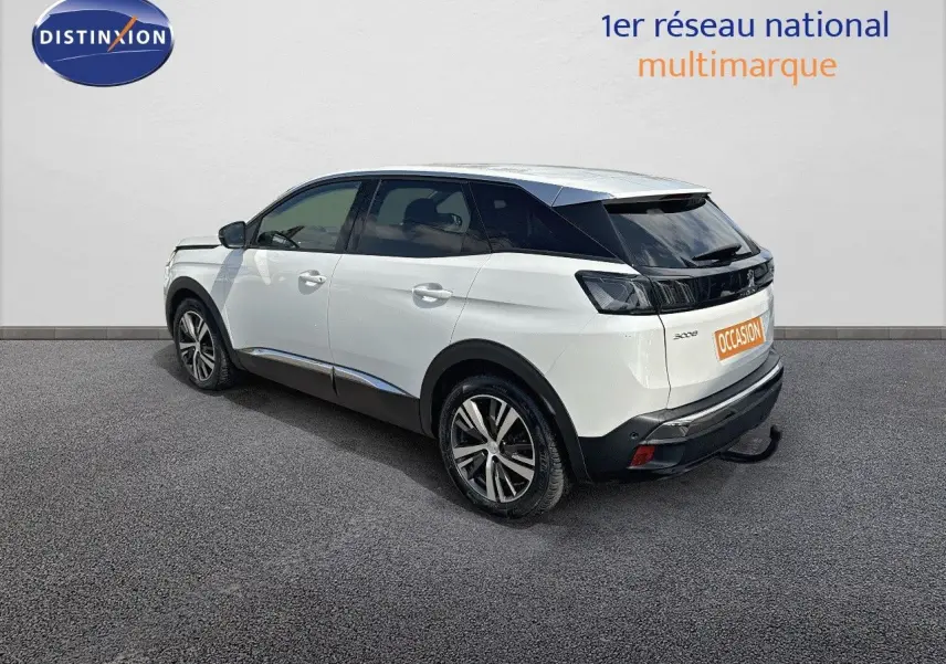 Peugeot 3008 blanc nacré en 3/4 arrière côté gauche, avec attelage et jantes bi-ton visibles.
