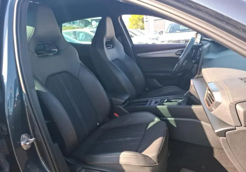 Vue intérieure côté conducteur de la CUPRA Formentor gris 2023, sièges sport en cuir et tableau de bord moderne.