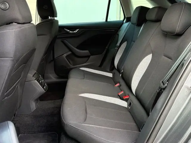 Vue intérieure côté droit des sièges arrière gris foncé et clair d'une Skoda Scala 2025, avec ceintures et appuie-têtes visibles.