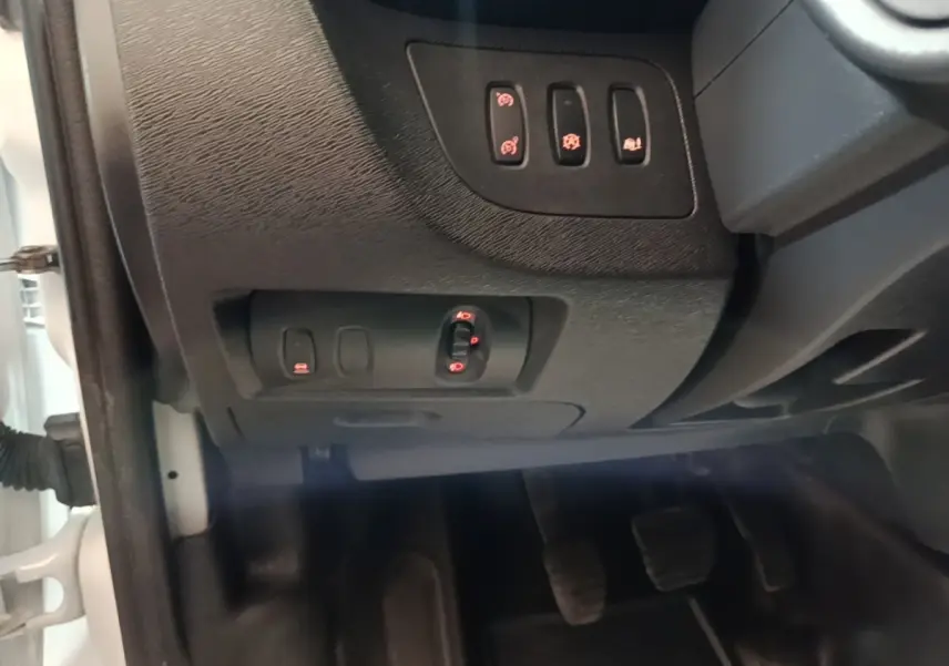 Détail intérieur côté conducteur du Renault Kangoo blanc 2020, montrant les commandes des rétroviseurs et aides à la conduite.