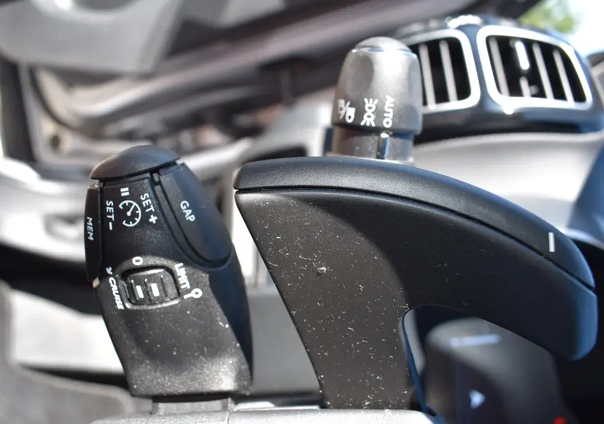 Gros plan sur la commande de régulateur de vitesse et limiteur du Citroën C5 Aircross 2024, intérieur noir.