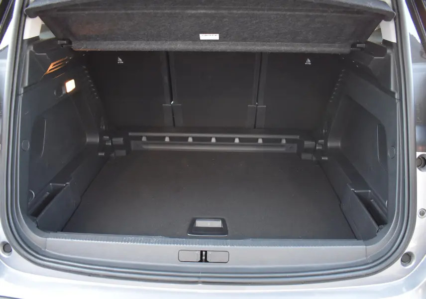 Coffre ouvert vu de l'arrière d'un Citroën C5 Aircross 2024 gris métallisé, espace de chargement spacieux et propre.