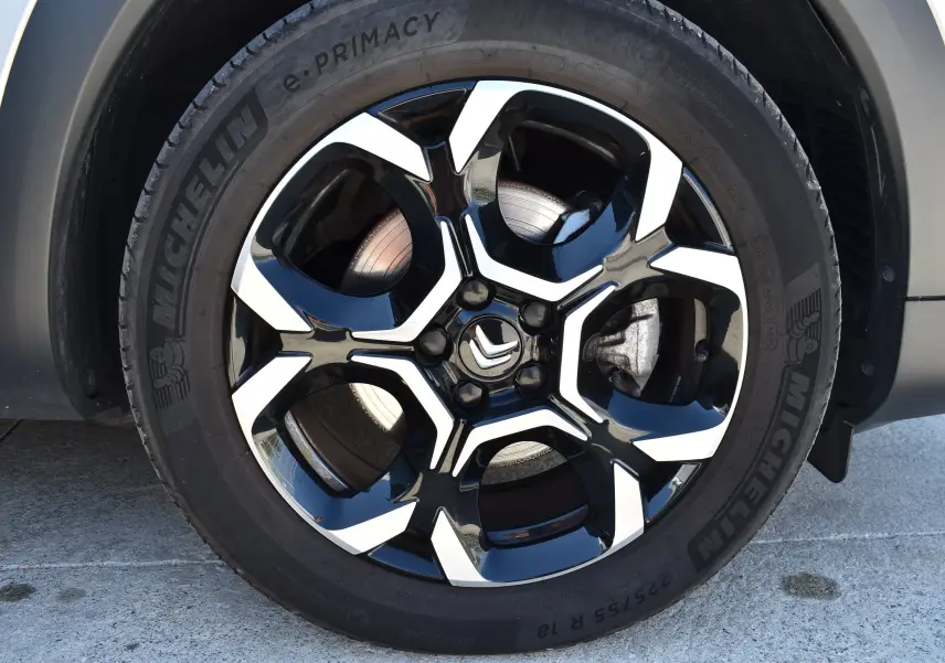 Gros plan sur la roue avant droite du Citroën C5 Aircross 2024, jante noire et argentée avec logo Citroën central.
