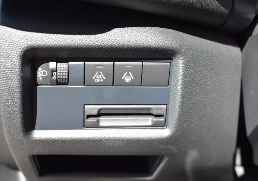 Gros plan sur les commandes de sécurité et réglage des phares du tableau de bord du Citroën C5 Aircross 2024.