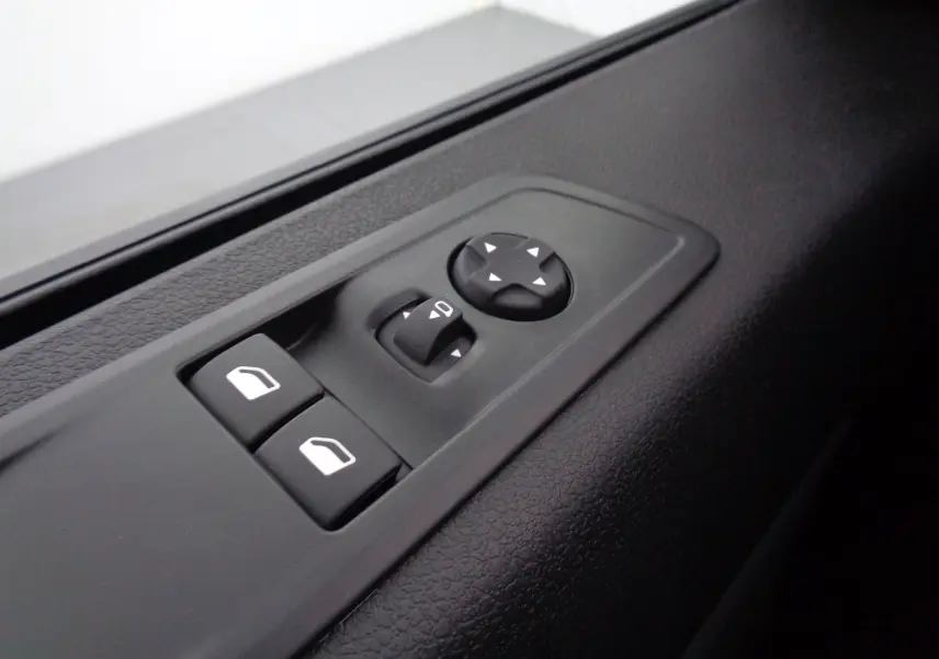 Gros plan sur les commandes de réglage des vitres et des rétroviseurs côté conducteur du Peugeot Expert Long noir perle métal.