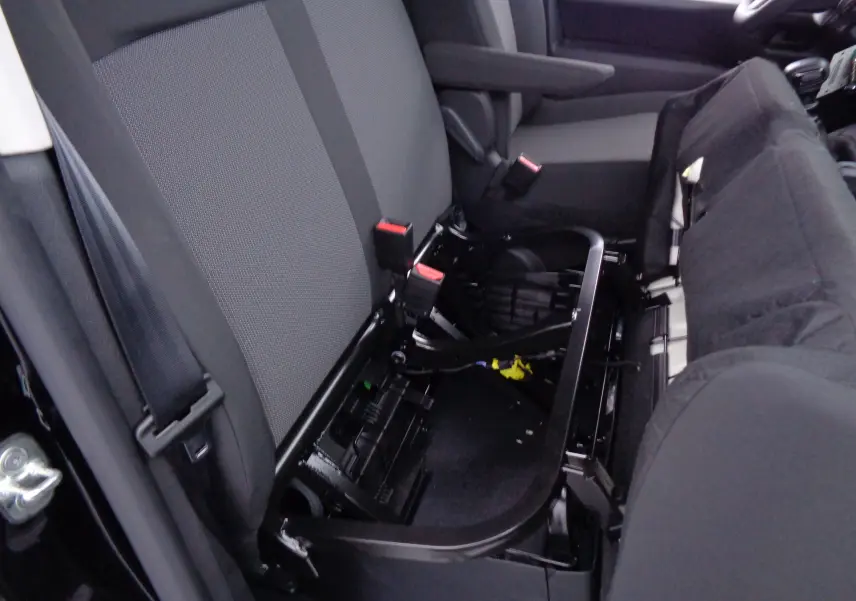 Vue intérieure côté gauche du siège avant relevé du Peugeot Expert Cabine Approfondie noir perle métal, montrant la structure métallique et l'assise en tissu noir.