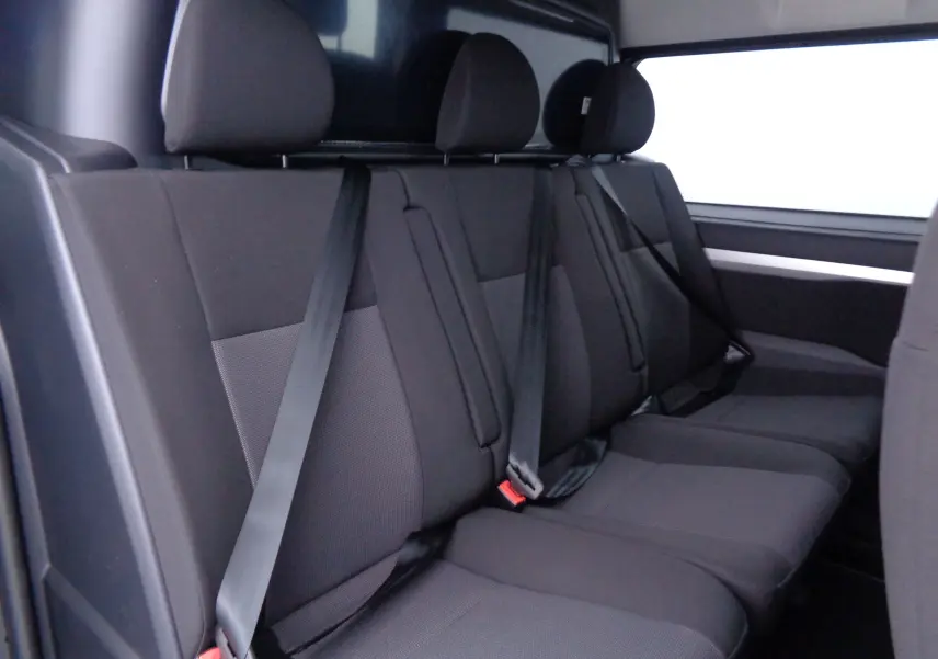 Banquette arrière en tissu noir avec ceintures de sécurité dans le Peugeot Expert Cabine Approfondie 2023, vue latérale intérieure.