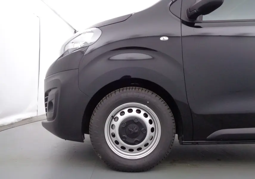 Gros plan sur la roue avant gauche et l'aile noire perle métal du Peugeot Expert Cabine Approfondie 2023, finition Confort Plus.