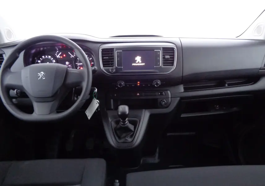 Vue intérieure avant du Peugeot Expert Long 2023, tableau de bord noir avec volant, écran tactile et levier de vitesses manuel.