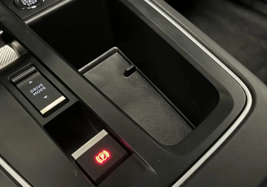 Gros plan sur la console centrale noire avec bouton frein à main électronique allumé et commande Drive Mode du Citroën C5 Aircross.