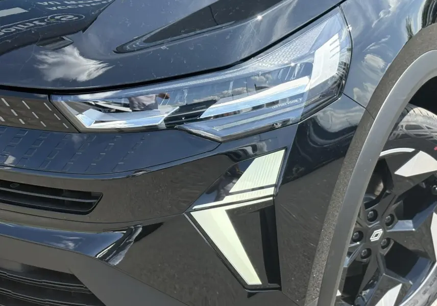 Gros plan sur l'avant droit du Renault Captur noir Étoile, mettant en valeur le phare LED Pure Vision et la jante aluminium 18 pouces.