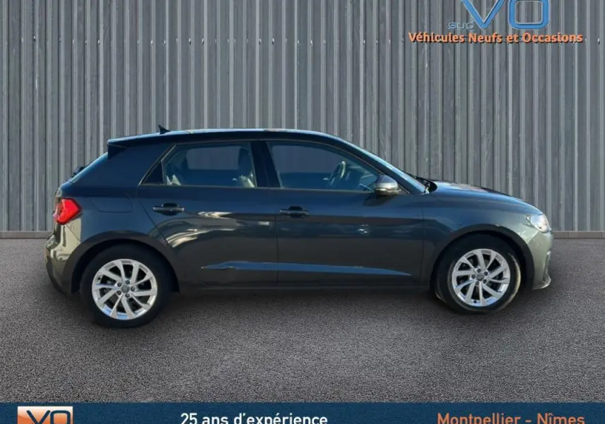 Profil latéral droit d'une Audi A1 Sportback gris foncé de 2019 avec jantes 16 pouces et vitres surteintées.