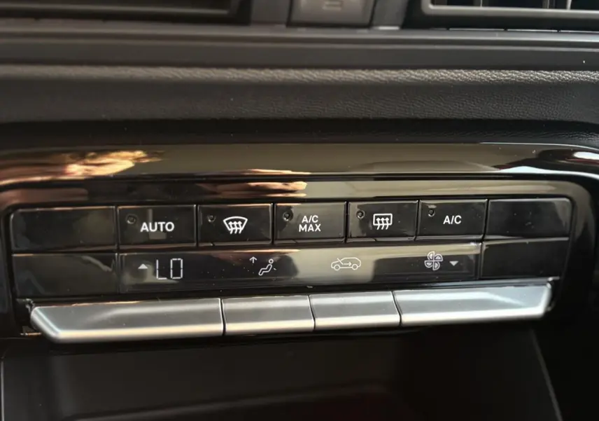 Gros plan sur les commandes de climatisation automatique noire et argentée du tableau de bord du Citroën C3 Aircross Hybrid 2025.