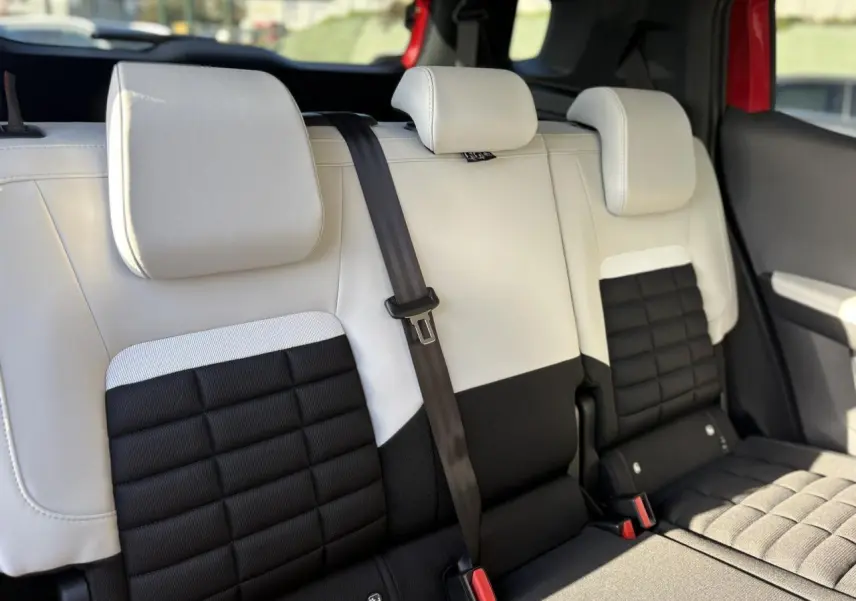 Vue rapprochée de la banquette arrière 2 places bicolore noire et blanche du Citroën C3 Aircross Hybrid 2025.