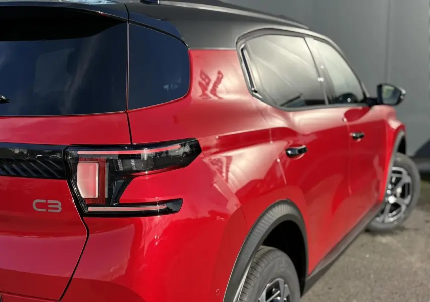 Vue 3/4 arrière droite du Citroën C3 Aircross rouge Elixir avec toit noir et feux arrière LED distinctifs.