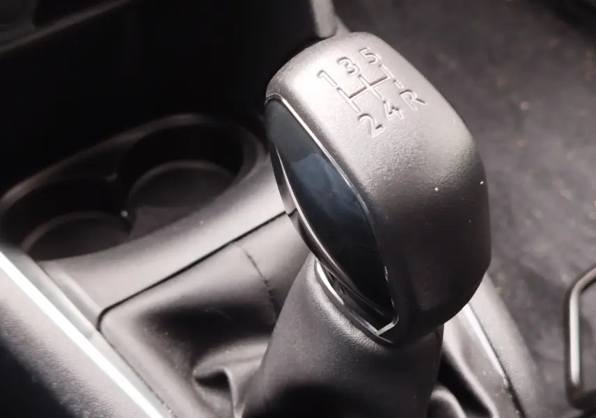 Gros plan sur le levier de vitesses manuel noir de la Peugeot 208 1.5 BlueHDi, montrant les rapports gravés.