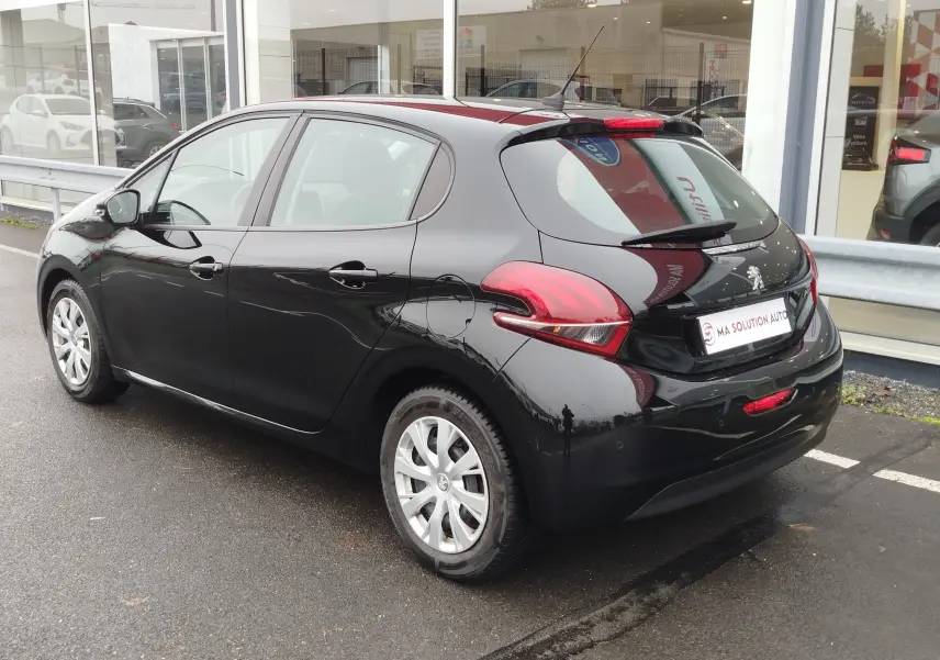 Vue 3/4 arrière droite d'une Peugeot 208 noire Perla Nera, avec feux arrière LED et jantes argentées.