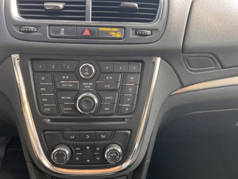 Tableau de bord central de l’Opel Mokka 2015 avec commandes audio, climatisation bi-zone et finitions chromées.