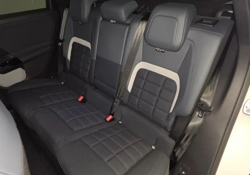 Vue intérieure arrière du Citroën C5 Aircross 2026, sièges tissu bleu avec inserts clairs et ceintures noires.