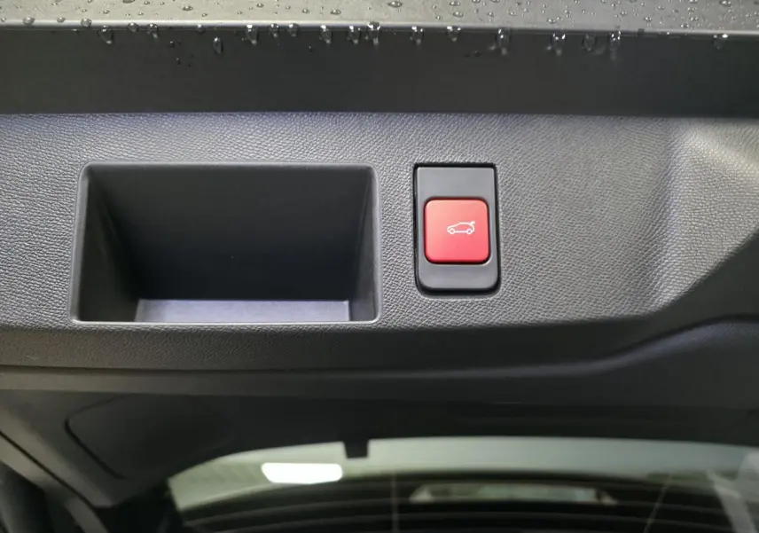 Bouton rouge d'ouverture du hayon mains libres sur la partie intérieure du coffre d'un Citroën C5 Aircross blanc.