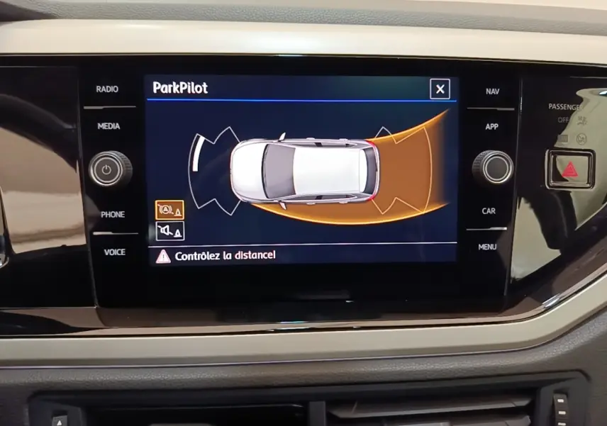 Écran tactile intérieur affichant l'aide au stationnement ParkPilot dans une Volkswagen Polo noire de 2020.