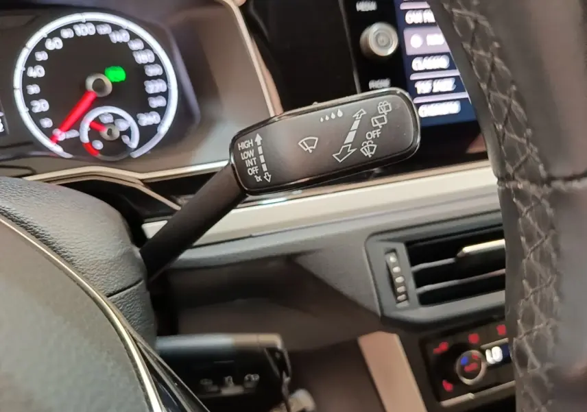 Gros plan sur la manette d’essuie-glace à gauche du volant cuir noir dans l’habitacle d’une Volkswagen Polo 2020.
