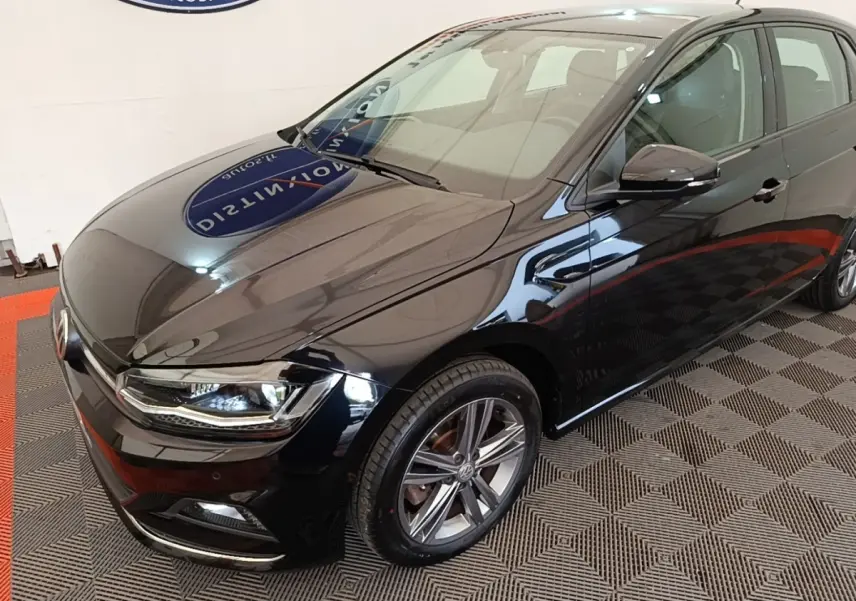 Volkswagen Polo noire vue en 3/4 avant droit, avec phares LED et jantes alliage distinctives.