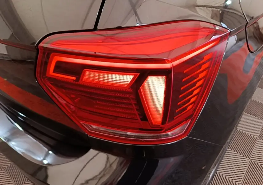 Gros plan sur le feu arrière droit rouge d'une Volkswagen Polo noire, soulignant les lignes modernes du modèle 2020.