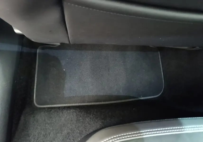 Vue intérieure du plancher arrière côté droit d'une Volkswagen Polo noire, tapis de sol noir visible sous les sièges.